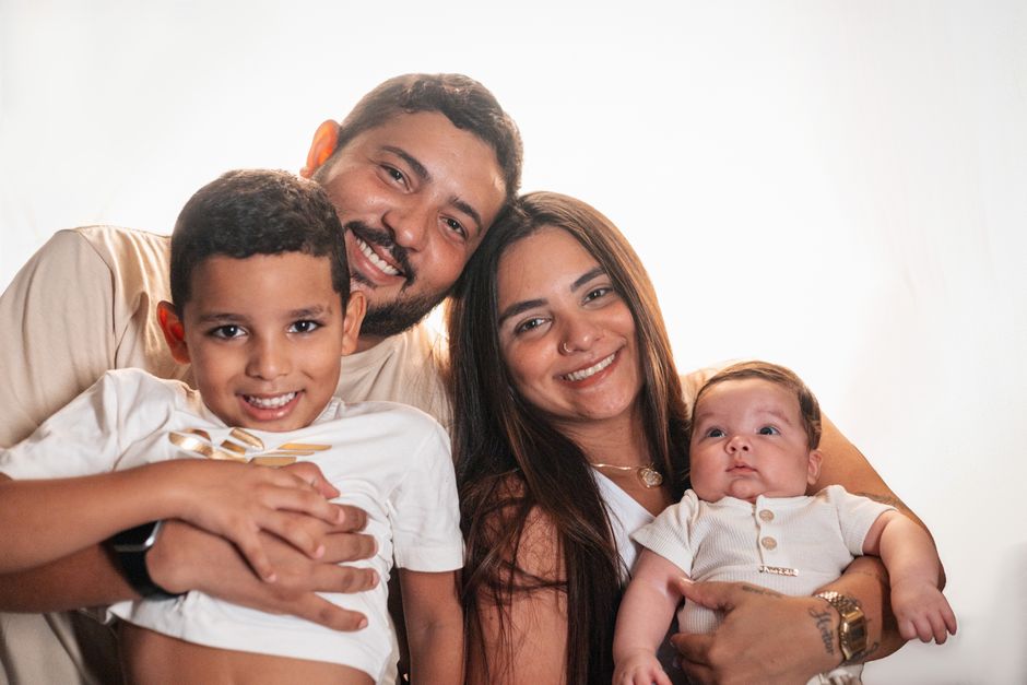 Joyful family portrait featuring smiling parents with their young children.