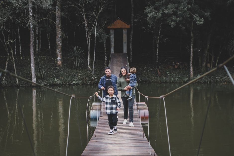 Family enjoying a day on a suspension bridge in a forest setting. Happy moments captured.