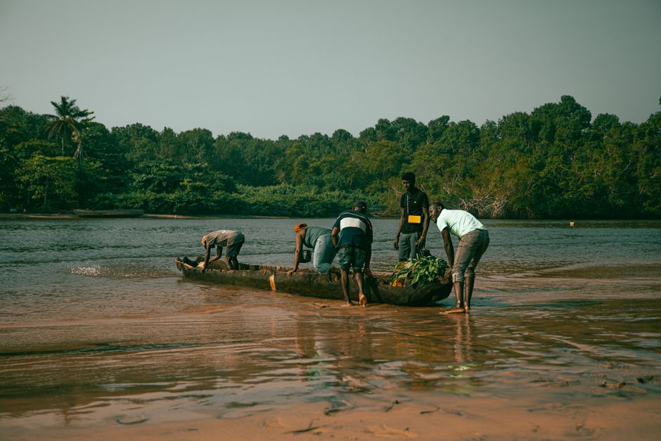 Fishermen in Cabinda, Angola, ready their canoe for a day on the river. Scenic landscape.