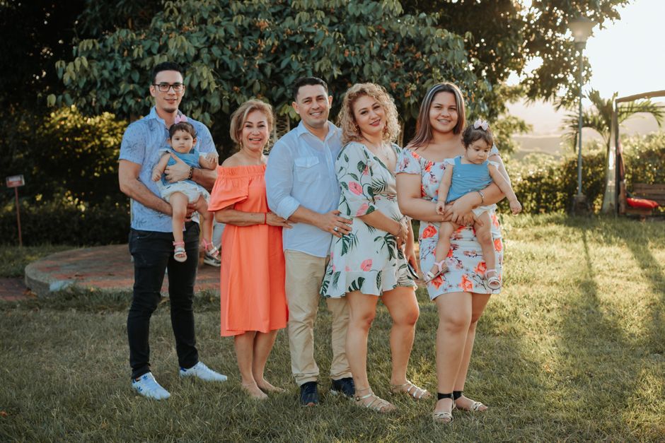 A joyful family posing together outdoors at sunset in a park.