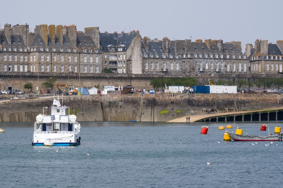 Captivating view of the historic Saint-Malo waterfront, featuring boats and stone buildings.