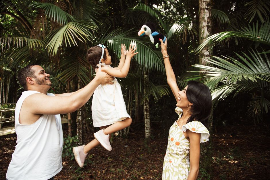 Joyful family moments captured in a tropical forest setting, highlighting parent-child interaction.