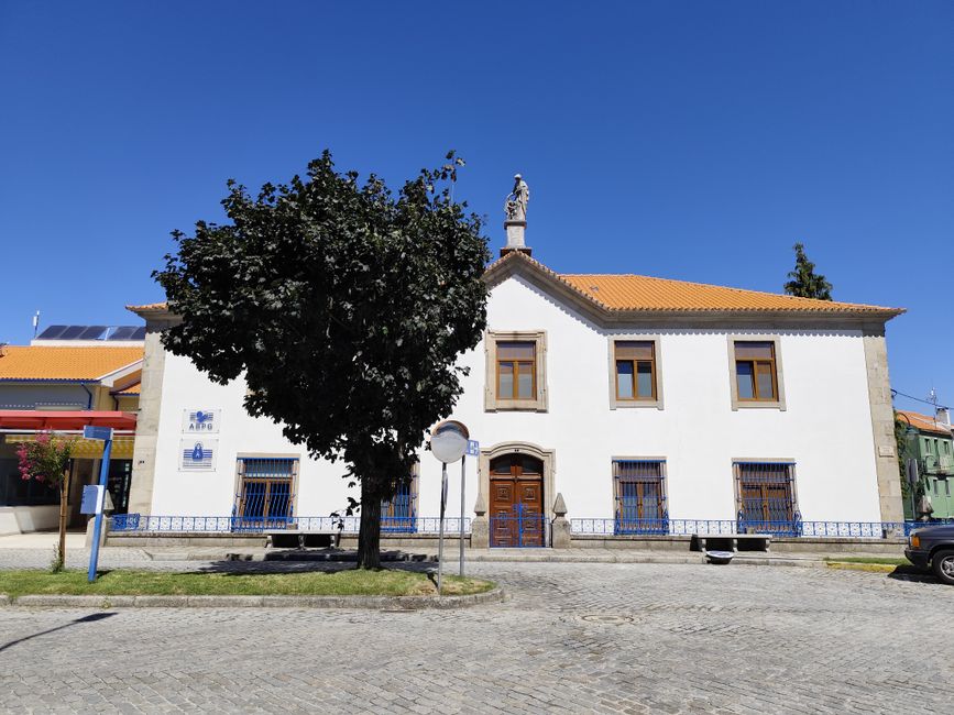 A historic building in Gouveia with a statue and intricate details under a clear blue sky.