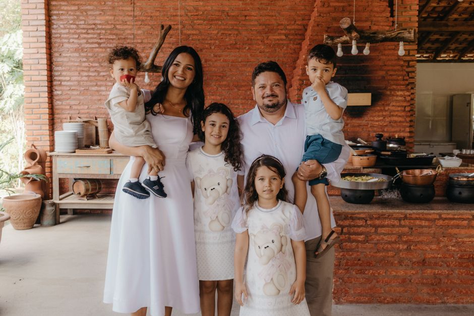 A joyful family portrait in a cozy rustic kitchen setting with a warm atmosphere.