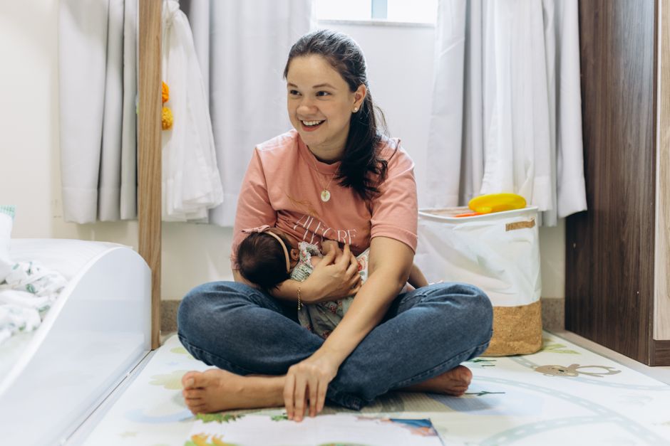 A joyful mother holding her baby in a bright, cozy room, showcasing motherhood and family warmth.